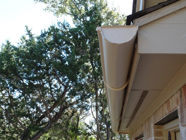 end cap of rounded cream colored gutters