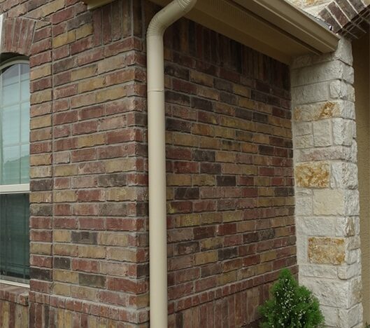 brick home with beige downspout