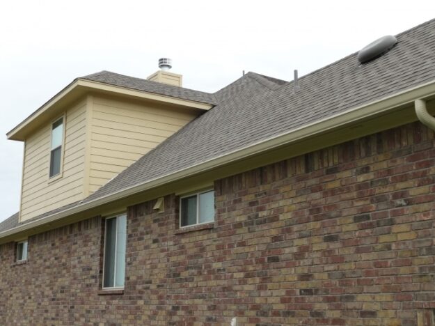 brick house with beige rain gutters