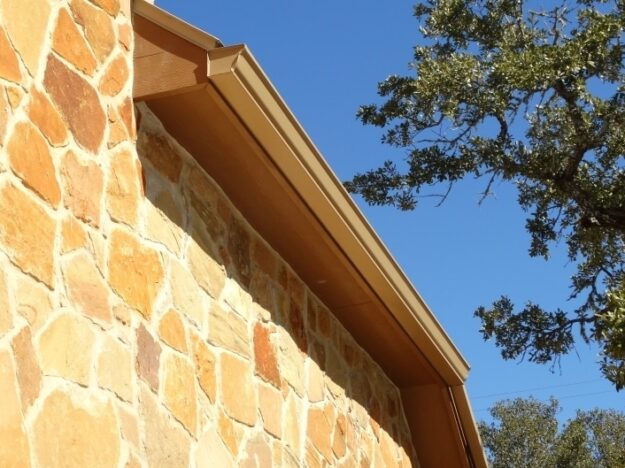 stone home with brown rain gutters