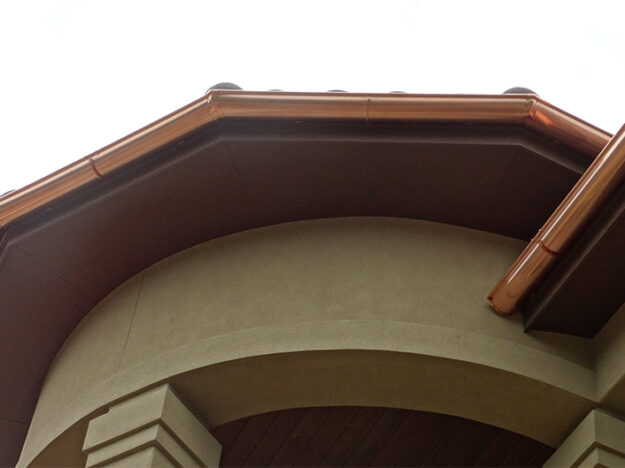 Upward view of a rounded copper gutter