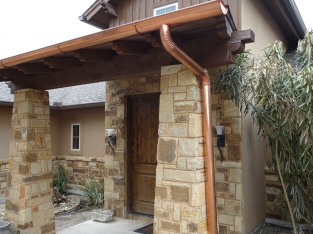 Copper gutter and downspout on a stone porch
