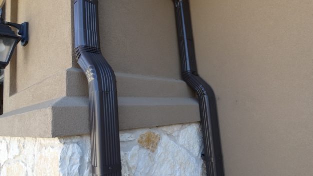 two dark brown downspouts