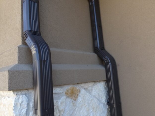 two dark brown downspouts