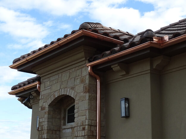 Multi-level copper gutter system on a spanish tile roof