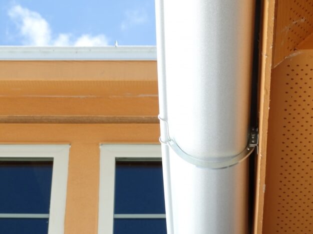 orange house with bracket mounted metal gutters