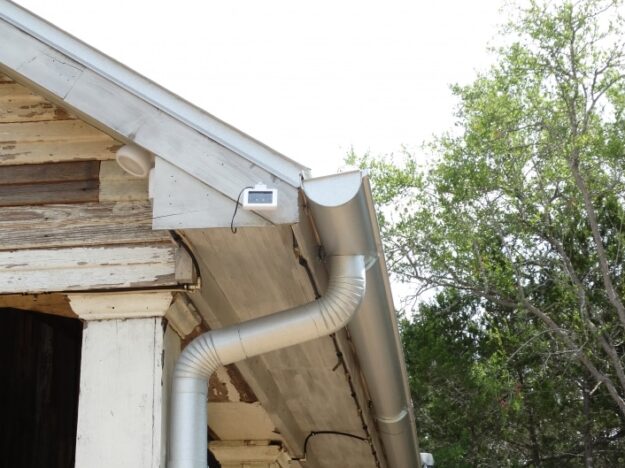 old house with new metal gutters and downspout