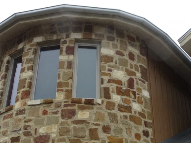 rounded gutter system on a stone house