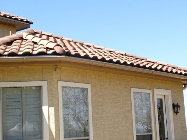 spanish tile roof and white gutters
