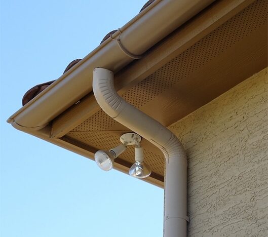 vertical downspout connected to brown gutters