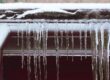 gutters with icicles next to a snowy roof