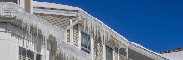 Ice dams and snow on roof and gutters after bitter cold