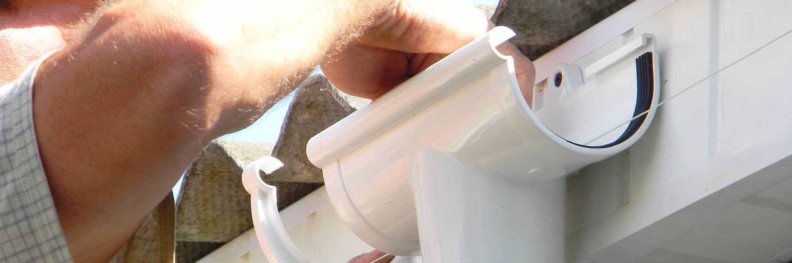 Contractor Installing Plastic Roof Gutter Holder For Dowspout Dr gutter flashing