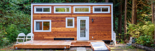 Small wooden home with white gutters and window frames