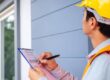 Construction worker evaluating the exterior of a home after completing a home renovation project.